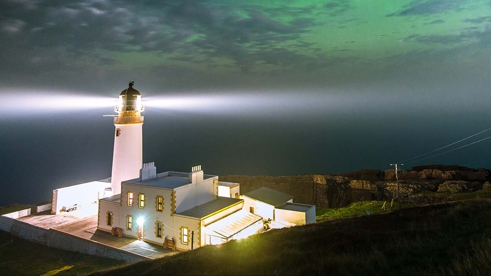 Un faro scozzese illuminato lungo la costa