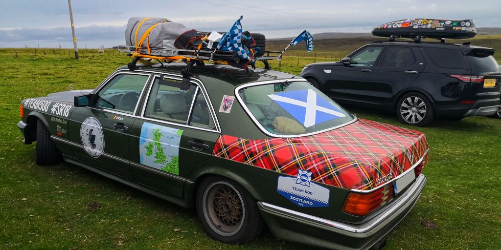 Un’auto decorata con il tartan e la bandiera scozzese durante un viaggio su strada