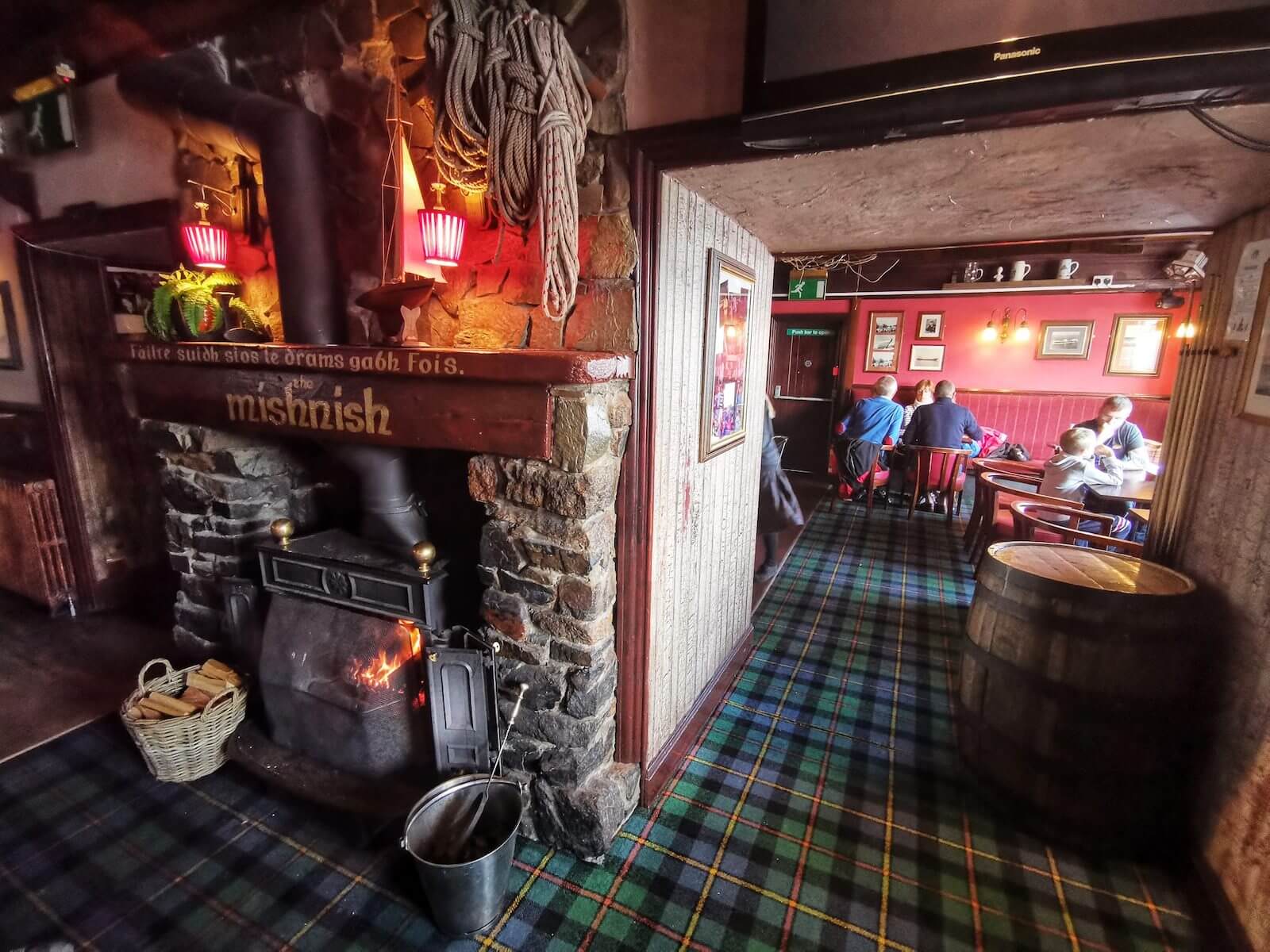 L’interno di un pub scozzese tradizionale, con stufa accesa e dettagli in tartan
