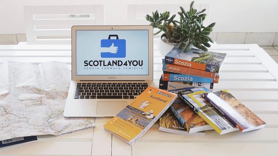 Guide di viaggio e mappe accanto a un computer Scotland4You